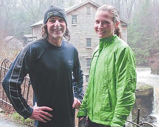 Terry McCluskey poses with friend and fellow runner Sarah Flament of Poland near Lanterman’s Mill at Mill Creek Park, which he says is his favorite place to train. McCluskey, 62, a native of Farrell, Pa., was named the Masters Division male runner of the year by the Road Runners Club of America.