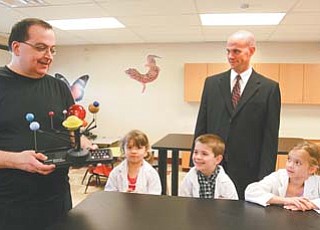 Dr. James Chengelis shows a solar-system model to Stadium Drive Elementary students Sami DeFabio, a kindergarten student; Sean Guerriero, also kindergarten; and Gia Triveri, a first-grader. Stadium
Drive Principal Jim Goske, center, said the school is grateful for Chengelis’ donation of a school science lab.