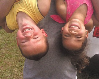 Megan Hruska says Evan Hruska, 3, and Johanna Ludt, 4, who are being held upside down, were getting anxious to see the last shuttle launch lift off at Kennedy Space Center for the last time.