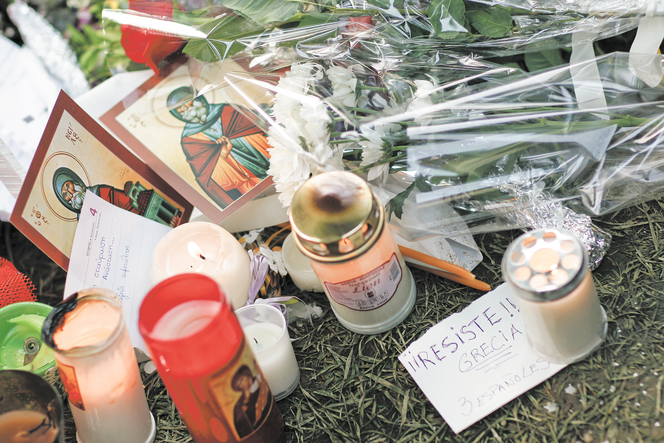 A note in Spanish sits among candles, flowers and cards that people left at the site where a 77-year-old
man shot himself in the head Wednesday on Syntagma square in Athens, Greece. Police clashed with demonstrators for a second day Thursday at the site.