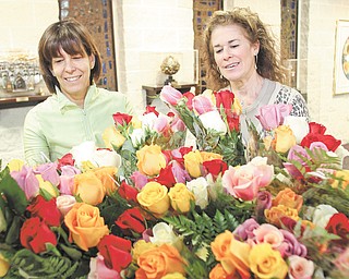 Debbi Grinstein, left, and Rochelle Miller, members of Temple El Emeth in Liberty, admire bundles of colorful and fragrant roses that will adorn Passover tables. Miller, chairwoman of the project for the temple Sisterhood, said the roses fundraiser began as a way to support Israeli entrepreneurs.