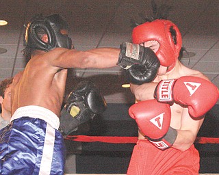 Chris Mitchell of Cardinal Mooney, in the blue trunks, lands a punch to the face of his opponent Jordan
Radich of Howland on Monday during their super middleweight bout in the underclass division on the opening
night of the 25th annual K.O. Drugs High School Boxing Tournament at the St. Lucy Palermo Banquet Center in
Campbell. Radich won by retirement in the second round.