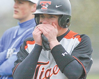 Springfield’s Hunter Snyder takes a second to warm up his hands after reaching first base during the bottom
of the second inning at Tuesday’s baseball game against Lisbon in New Middletown. The Tigers were
leading 12-2 when the game was suspended in the bottom of the inning due to inclement weather. The
teams will finish today before their regularly-scheduled clash at Lisbon.