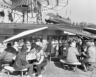 Crowds gather in a concession area underneath the former Idora Park’s rocket ride at an auction of park items shortly after the amusement park next to Mill Creek Park closed after 85 years.
