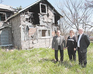 Austintown Township Trustee David Ditzler, left, Fiscal Officer Laurie Wolfe and Zoning Inspector Darren Crivelli stand in front of a dilapidated property at 252 Four Mile Run Road, one of six homes on the township’s demolition list. But lack of funding is preventing the township from demolishing four of them, including this abandoned house.