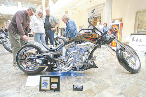 Dan Kryger of Hermitage, Pa., points out details of his son’s Cobrathemed motorcycle to Jeanne and Del Hanuschak of Boardman and Kay Chaszeyka, who is the mother of the artist, at the exhibit of airbrush art by Steve Chaszeyka of New Middletown at the Butler.