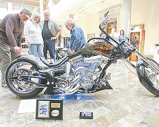 Dan Kryger of Hermitage, Pa., points out details of his son’s Cobrathemed motorcycle to Jeanne and Del Hanuschak of Boardman and Kay Chaszeyka, who is the mother of the artist, at the exhibit of airbrush art by Steve Chaszeyka of New Middletown at the Butler.