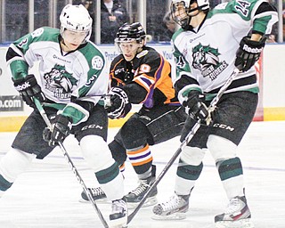 Dylan Margonari of the Youngstown Phantoms, center, keeps his eye on the puck as Cedar Rapids RoughRiders’ John Gilmour, left, and Ian Brady try for control during the first period of Monday’s playoff game at the Covelli Centre.