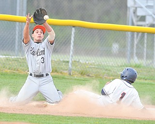 Howland third basemen Tim Schulman (3) goes to his knees to catch a throw as Austintown Fitch’s Alex Sierra slides into third base during Tuesday’s game.