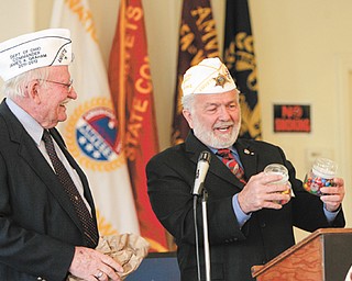 James Graham, AMVETS Department of Ohio commander, left, gives John “J.P.” Brown III of Boardman, former state and natonal AMVETS commander, candy as an honorary gift for AMVETS Post 44, 305 Elm St., Struthers, which had a grand opening Wednesday.