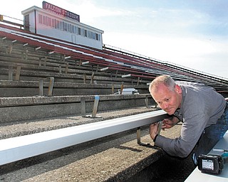 John McCague, of Buckeye Bleacher Repair in Sunbury, Ohio, installs new aluminum bleachers Wednesday morning in a section of Falcon Stadium in Austintown. The bleachers are replacing the last remaining section of original wooden bleachers, which were installed when the stadium was built in 1970.