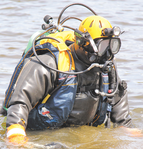 John Mesmer of Struthers slowly walks backward into McKelvey Lake in Youngstown where the Mahoning County
sheriff ’s dive team trained Sunday in locating evidence at the bottom of a lake.