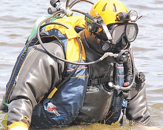John Mesmer of Struthers slowly walks backward into McKelvey Lake in Youngstown where the Mahoning County
sheriff ’s dive team trained Sunday in locating evidence at the bottom of a lake.