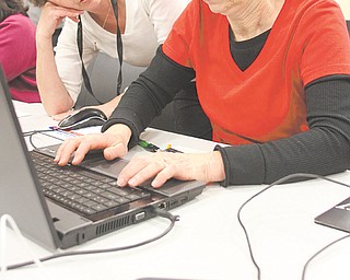 Supervisor and trainer Judy Sluss, left, of the Public Library of Youngstown and Mahoning County helps Theresa Semchee during a class on downloading eBooks.