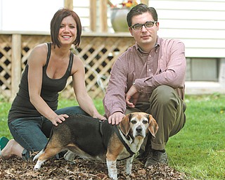 Alison Morris and her friend Nathaniel Riggle pose with Toby, one of two beagles attacked by a pit bull in Morris’ yard. The attack left both with a decreased sense of security.