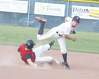 Fitch’s Tony Adams (4) follows through as Nick Gigax (8) of Struthers tries to break up the play during an All-American Conference baseball game Wednesday in Austintown. The Falcons edged the Wildcats, 9-8.