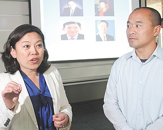 Youngstown State University professors Helen Han and Peter Chen have completed a paper on how chief executive officers’ portraits form individual views on a company’s success. They addressed a class at YSU
recently. Portraits of CEOs are projected behind them.