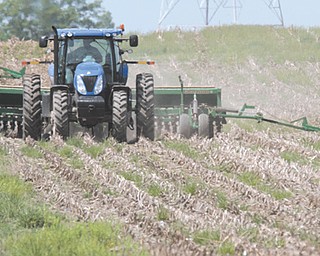 Wayne Greier, owner of Greier Ag Center Inc. near Canfield, works the crops atop his tractor. Despite the late April freeze in much of the state, the Ohio Corn and Wheat Growers Association predicts a record year for corn based on prices and earlier than normal warm weather.