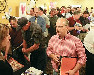 The line to speak to officials from Chesapeake Energy stretches out the door at the job fair that was part of the Columbiana County Economic Development Summit. The event had filled the parking lot at the East Liverpool Motor Lodge well before the fair’s 10 a.m. Monday start.