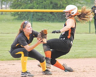 Howland’s Emily Price (9) slides into second base past Cuyahoga Falls’ Hannah Shane (1) during a Division I
tournament softball game Monday at Howland Township Park. Freshman Hannah Burke tossed a no-hitter to
lead Howland to the 10-0 victory.