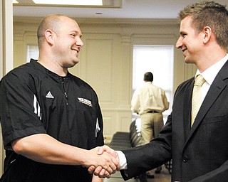 Frank Caputo, left, and Andy Vlajkovich shake hands after being named the new girls and boys basketball coaches, respectively, at Warren Harding High School during a board of education meeting at the Warren administration building Tuesday.