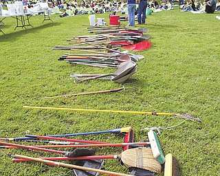 Brooms, rakes and shovels lie waiting for more than 300 students from Heartland Christian School at Firestone Park in Columbiana. Students, listening to director of school and community relations Linda Brandenstein, gathered at the park Wednesday to weed, paint and clean for School Service Day.