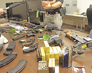 Lt. Gerard Slattery, commander of the Youngstown police vice squad, displays an arsenal of firearms, magazines and ammunition, together with drugs and $2,000 in cash, at a Wednesday afternoon news conference. The items were seized in a Tuesday raid on a house at 931 McHenry St. on the city’s East Side.