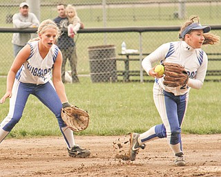 Hubbard’s Samantha Dudley, left, watches as teammate Taylor Barton scoops up a ground ball near a muddy
second base during the top of the seventh inning in their Division II tournament softball game Wednesday against
Niles at Harding Park in Hubbard. The Eagles downed the Red Dragons, 5-2.