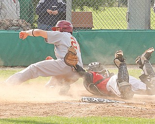 Drew DelSignore (22) of Mooney is tagged out at home by Struthers catcher Cody Bova during their Division II sectional semifinal baseball game Thursday at Cene Park in Struthers. The Cardinals defeated the Wildcats, 15-2, to advance to the final today against Niles at Waddell Park.