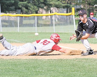 Niles baserunner Patrick Barrett dives back into first base as Canfield’s Tony Mehle awaits a throw during a recent game at Canfield. Thursday, Canfield will play Poland at Cene Park in a Division II district semifinal.