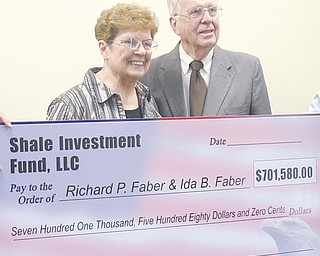 Ida and Richard Faber of Fowler receive their check of $701,580 for signing oil and gas leases with Shale Investment Fund LLC on Wednesday at the Fowler Community Center.