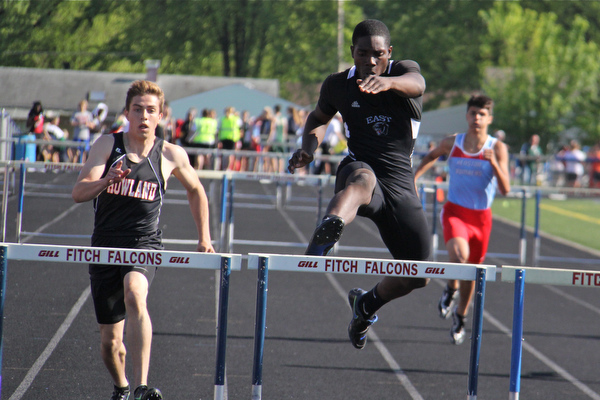 Valantino Sewell of Youngstown East jumps over the final hurdle to take first place in the mens 300 meter hurdle while being followed closely by Andrew Hamilton of Howland during Fridays Division one district championship track meet at Austintown Fitch High School.  Dustin Livesay  |  The Vindicator