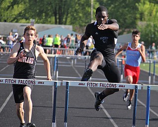 Valantino Sewell of Youngstown East jumps over the final hurdle to take first place in the mens 300 meter hurdle while being followed closely by Andrew Hamilton of Howland during Fridays Division one district championship track meet at Austintown Fitch High School.  Dustin Livesay  |  The Vindicator