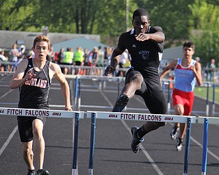 Valantino Sewell of Youngstown East jumps over the final hurdle to take first place in the mens 300 meter hurdle while being followed closely by Andrew Hamilton of Howland during Fridays Division one district championship track meet at Austintown Fitch High School. Dustin Livesay | The Vindicator