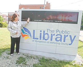Janet Loew, communications and public-relations director, shows off the new electronic event sign in front of the main library on Wick Ave.