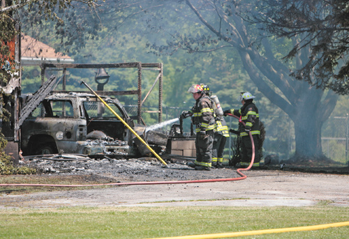 Firefighters work on extinguishing hot spots left over from a blaze that consumed the garage and much of a house at 8869 Duck Creek Road in Ellsworth Township. Fire crews from almost a dozen departments
responded for mutual aid, and the homeowner made it out without injury. The fire remains under investigation, and the cause is not yet known.