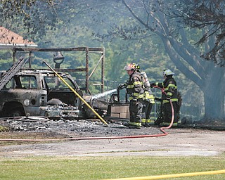 Firefighters work on extinguishing hot spots left over from a blaze that consumed the garage and much of a house at 8869 Duck Creek Road in Ellsworth Township. Fire crews from almost a dozen departments
responded for mutual aid, and the homeowner made it out without injury. The fire remains under investigation, and the cause is not yet known.