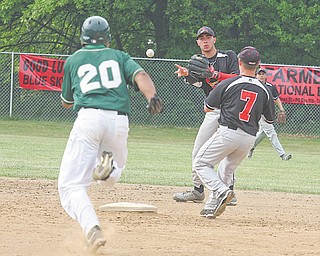 Canfield’s Joe Tuchek flips the ball to teammate Mike Ross (7) as Ursuline’s Paul Pegues (20) heads toward second base during Tuesday’s game in Canfield.
