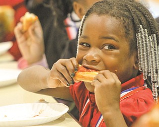 Cyra Cross, a member of the Principal’s Club, digs into a slice of pizza at the party.