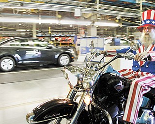 Gary “Bones” Mowen of Niles wears an Uncle Sam costume as he rides his Harley-Davidson motorcycle through
the General Motors Lordstown plant as part of a fundraising ride Thursday.