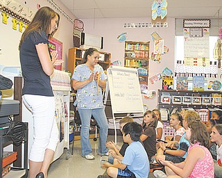 Melissa Kmetz, third-grade teacher at Lakeview Elementary, left, stands with Tiffany Minor, a staff member at the Animal Welfare League of Trumbull County, as the students present a check for $1,632 that the school raised to benefit the animals at the shelter.