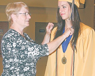 Cindy Hynes fixes up her daughter Kelly before Lowellville High School’s graduation Sunday.