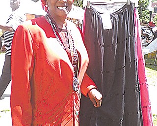Gwenn Morgan, one of the coordinators of Gospel Sunday at the African-American Achievers Festival in Warren,
stands by a display of African clothing.