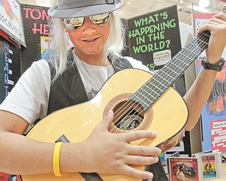 South Range seventh-grader Chris Herubin plays the guitar Tuesday while in character as Tom Petty. All seventh-graders researched projects about musicians who have been inducted into the Rock and Roll Hall of Fame and Museum in Cleveland.