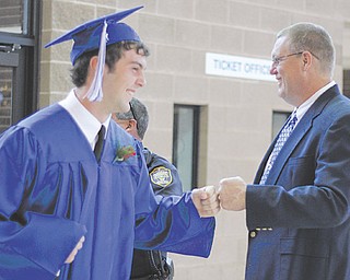 Poland graduate John Bannon gets greeted by assistant basketball coach Rich Black while entering the fieldhouse
for commencement exercises Sunday.