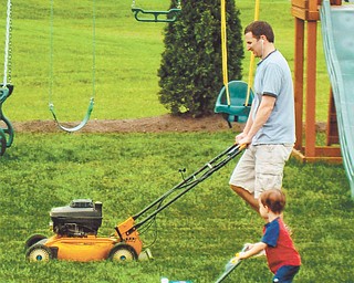 Doug Burns gets some mower help from Owen Burns.