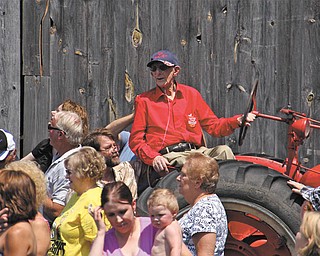 Surrounded by friends and family, Earla Smith sits on a tractor at his farm during a recent celebration staged in honor of the 104-year-old.