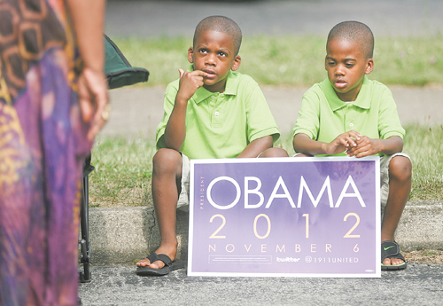 Twin brothers Brycen and Brayden Mahone, 5, of Youngstown hold their re-election sign at the rally for President Barack Obama and voter-registration drive at the former Mr. Paul’s Bakery at Glenwood and Parkview avenues in Youngstown. The event, sponsored by 1911 United, which consists of current and former members of Kappa Alpha Psi and Omega Psi Phi fraternities, took place Sunday afternoon. Below, Jermal Giles, 22, a member of 1911 United and Omega Psi Phi, performs for the crowd.