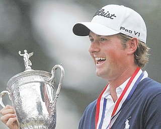 Webb Simpson smiles as he holds up the trophy after winning the U.S. Open Championship at The Olympic Club in San Francisco.