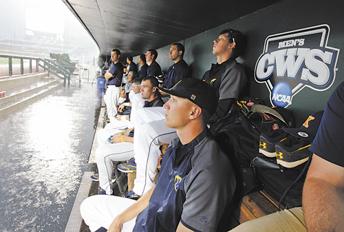 Kent State players wait in the dugout as heavy rain drenches the field before their College World Series
elimination baseball game against South Carolina on Wednesday in Omaha, Neb. The game was postponed
until noon today.
